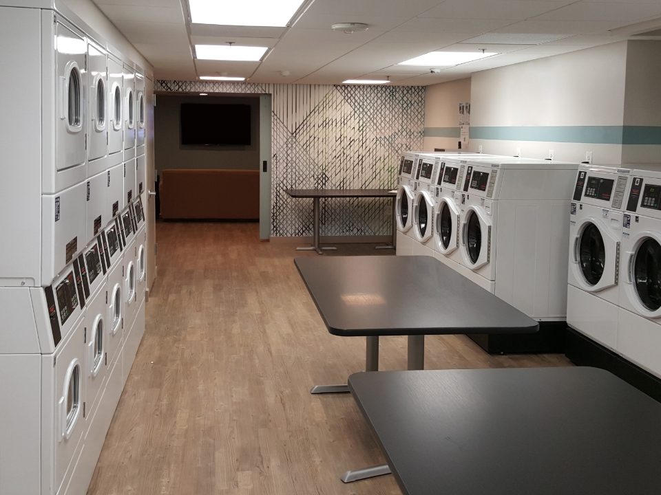 Homepage banner image showing an empty laundry room with laundry machines against the walls