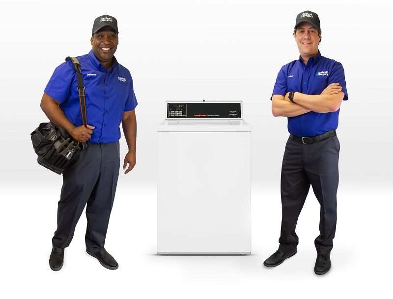 Two Caldwell & Gregory employees standing on either side of a laundry machine