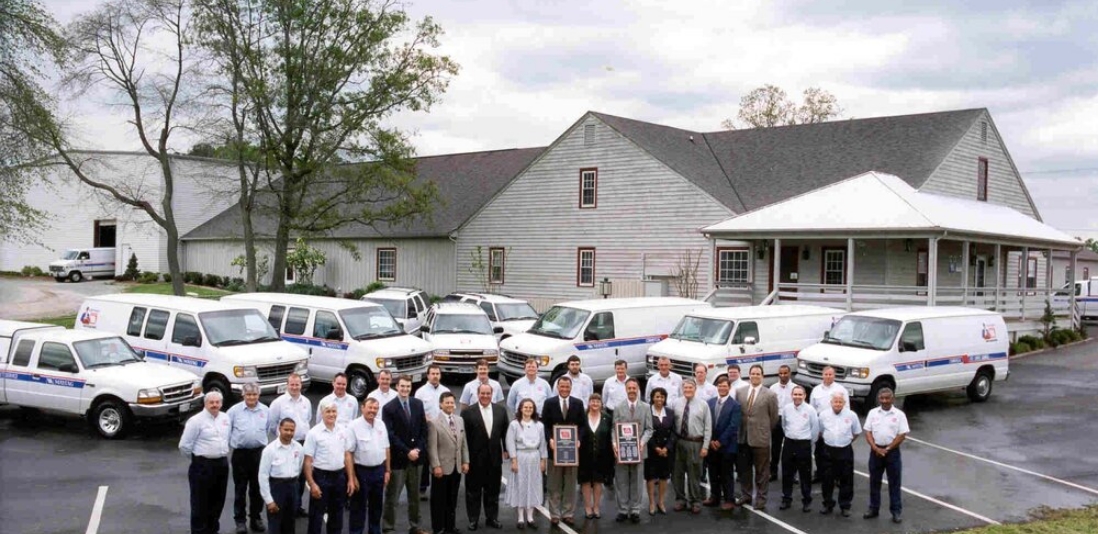 Caldwell & Gregory employees standing in front of their service vans in a parking lot