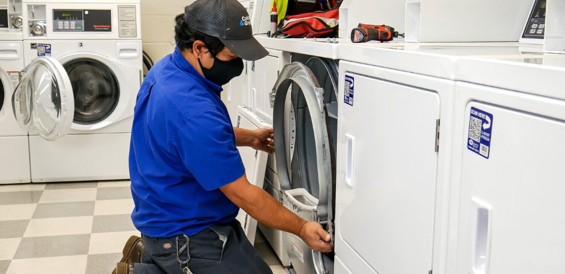 Caldwell & Gregory service technician taking a washing machine door off to work on it