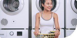 Hero image for blog post. College woman holding a laundry basket and smiling